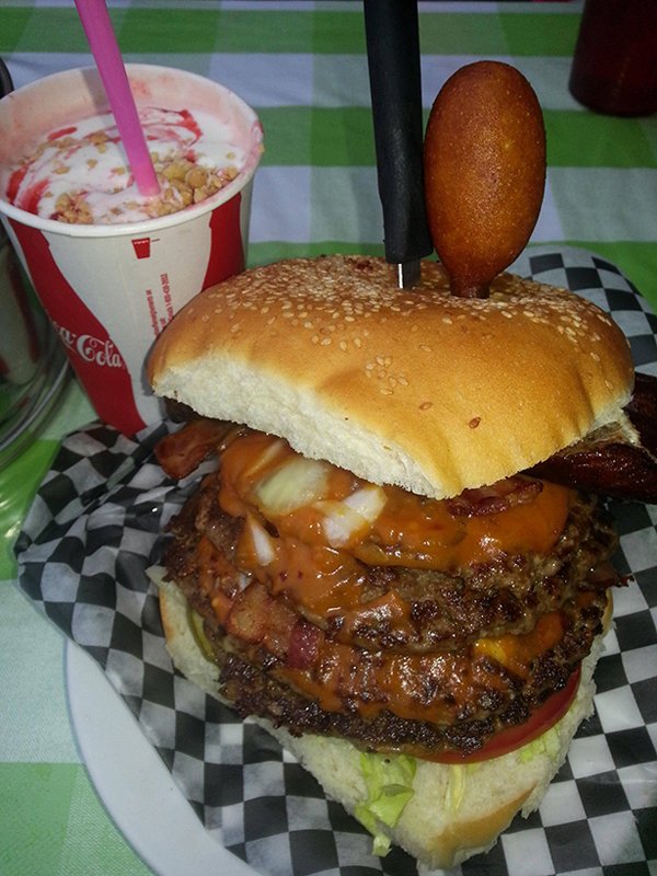 A mouthwatering burger and a tantalizing drink on a plate.