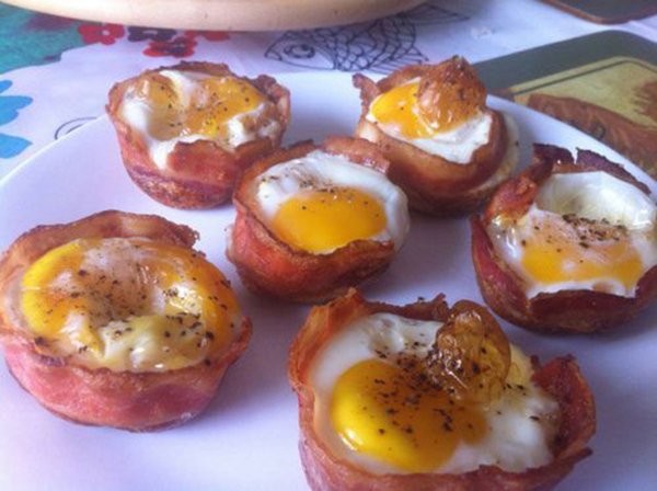 Bacon-wrapped eggs plated seductively, a foodie's dream.