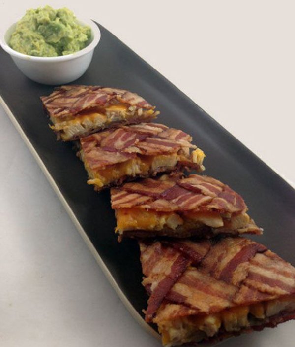 Bacon quesadillas on a black plate.