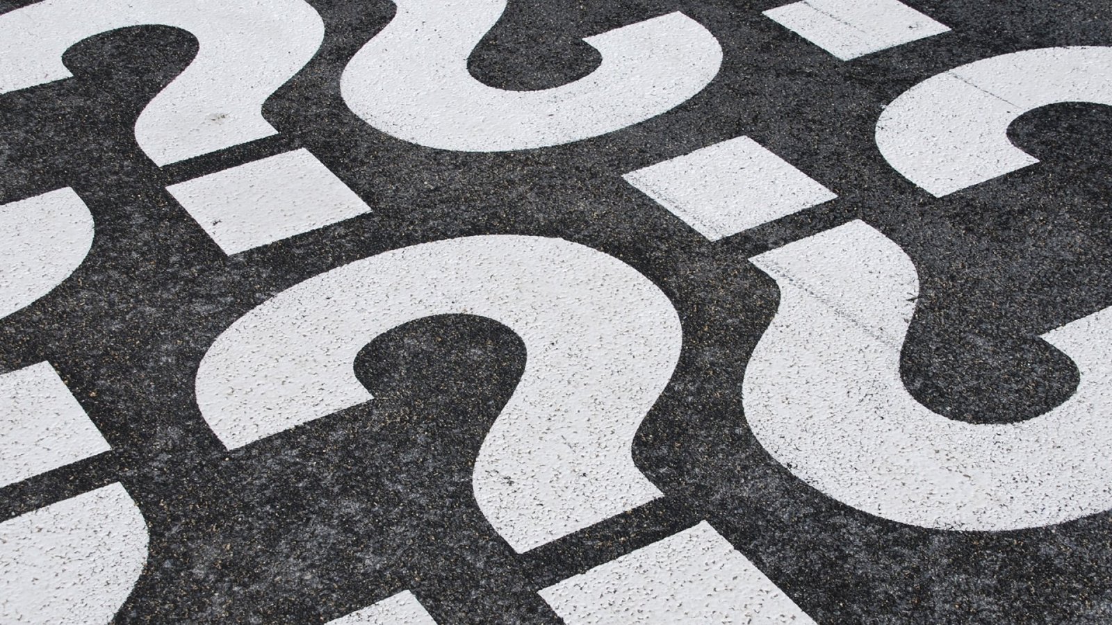 A group of question marks painted on the ground, prompting people to Stop Being Dumb On The Internet.