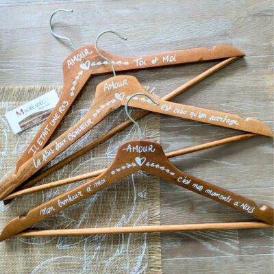 Cintres en bois personnalisés avec inscriptions d'amour.