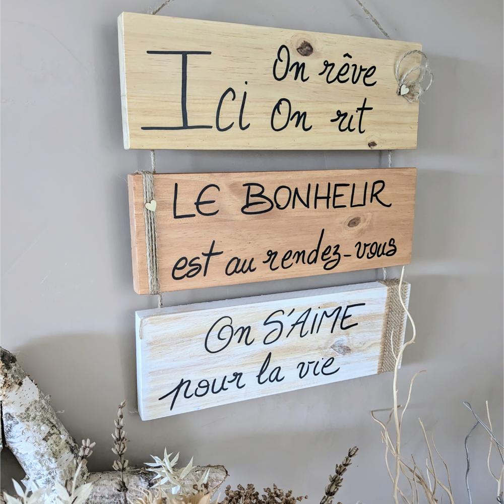 Plaques en bois avec citations inspirantes accrochées au mur.
