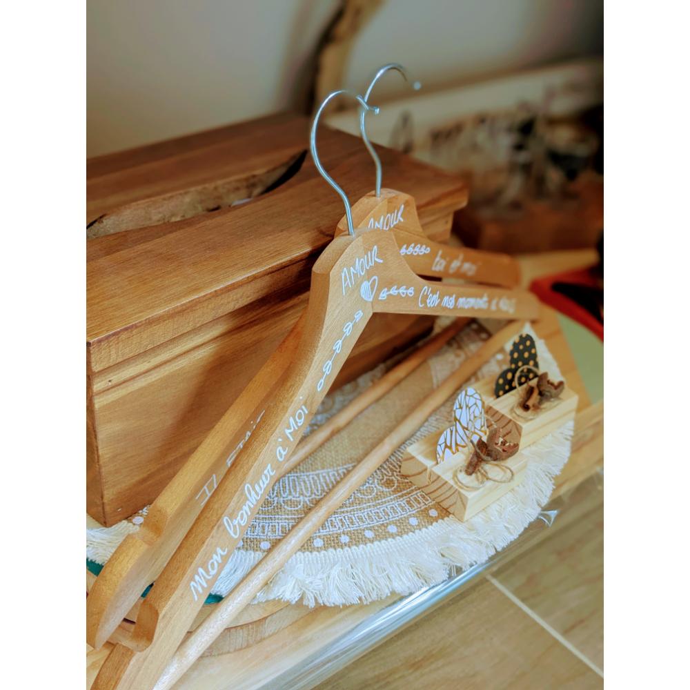 Cintres en bois avec inscriptions blanches.