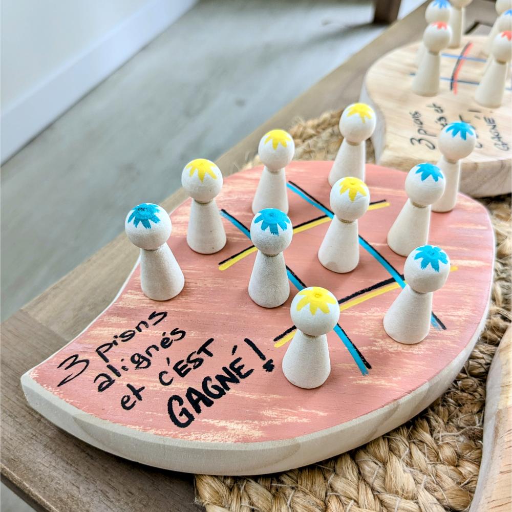 jeu-morpion-bois-tactique-pions-enfant-personnalisé-artisanal Jeu de société avec pions colorés sur plateau.