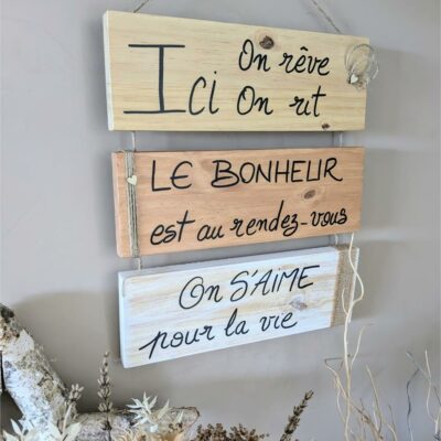 Plaques en bois avec citations inspirantes accrochées au mur.