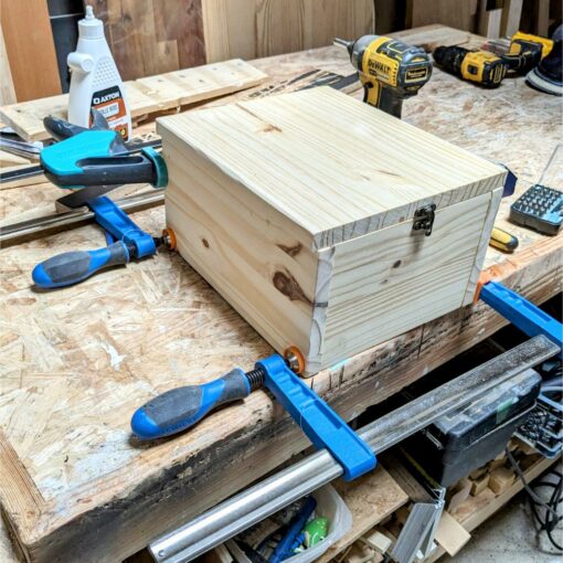 Boîte en bois avec serre-joints sur établi.