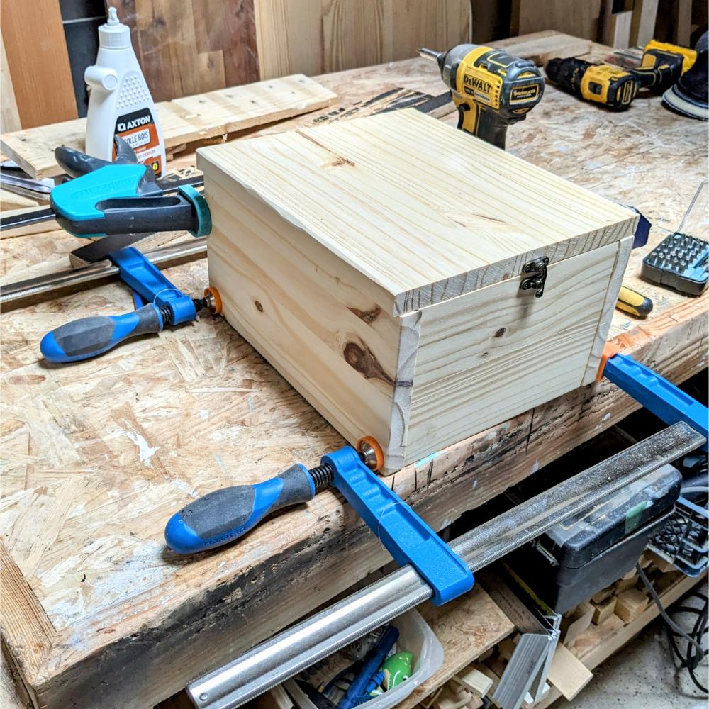 urne-évènements-mariage-bois-fleurs-séchées-personnalisé-décoration-artisanal Boîte en bois avec serre-joints sur établi.