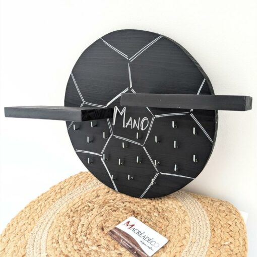 Étagère murale hexagonale noire avec crochets.