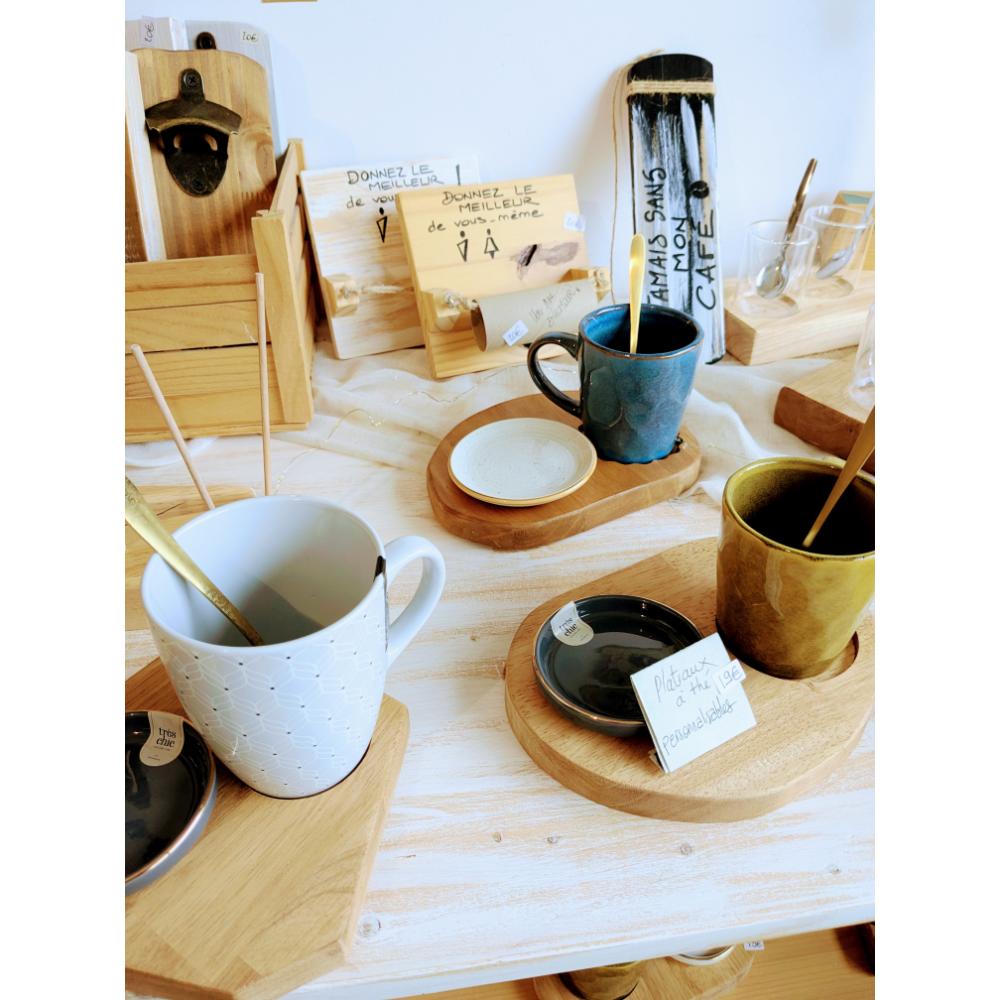 plateau-thé-bois-table-socle-tasse-cadeau-artisanal-personnalisé Tasses colorées sur plateaux en bois dans boutique.