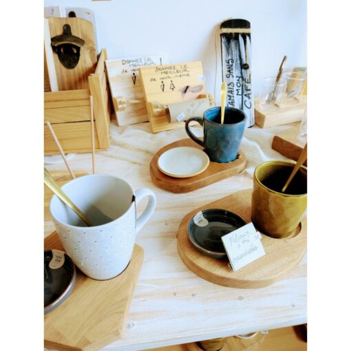 Tasses colorées sur plateaux en bois dans boutique.