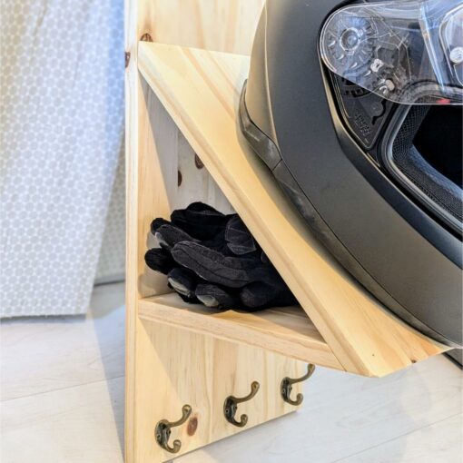 Casque moto et gants sur étagère en bois.