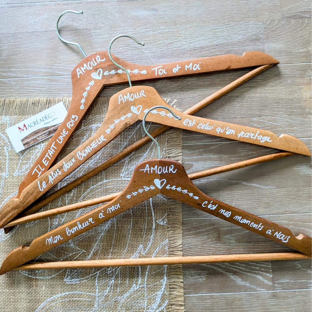 Cintres en bois personnalisés avec inscriptions d'amour.