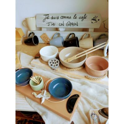 Tasses et bols colorés sur une table rustique.