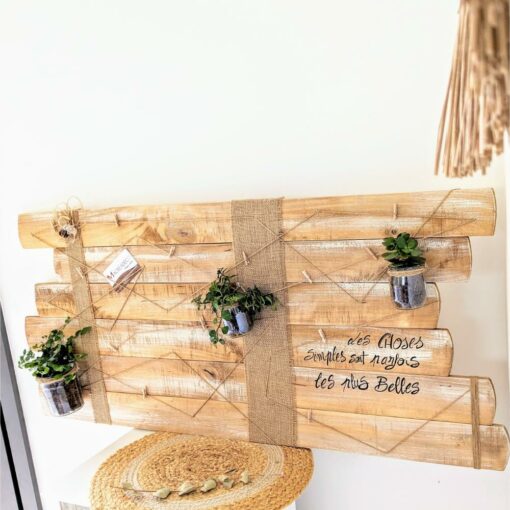 Décoration murale en bois avec plantes suspendues.
