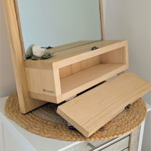 Miroir en bois avec compartiment ouvert.