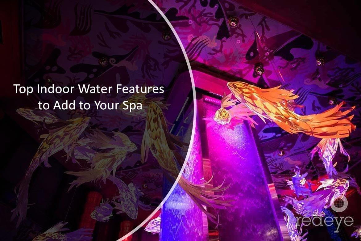 Colorful indoor water feature with illuminated water cascading down, surrounded by artistic fish decorations, enhancing spa ambiance.