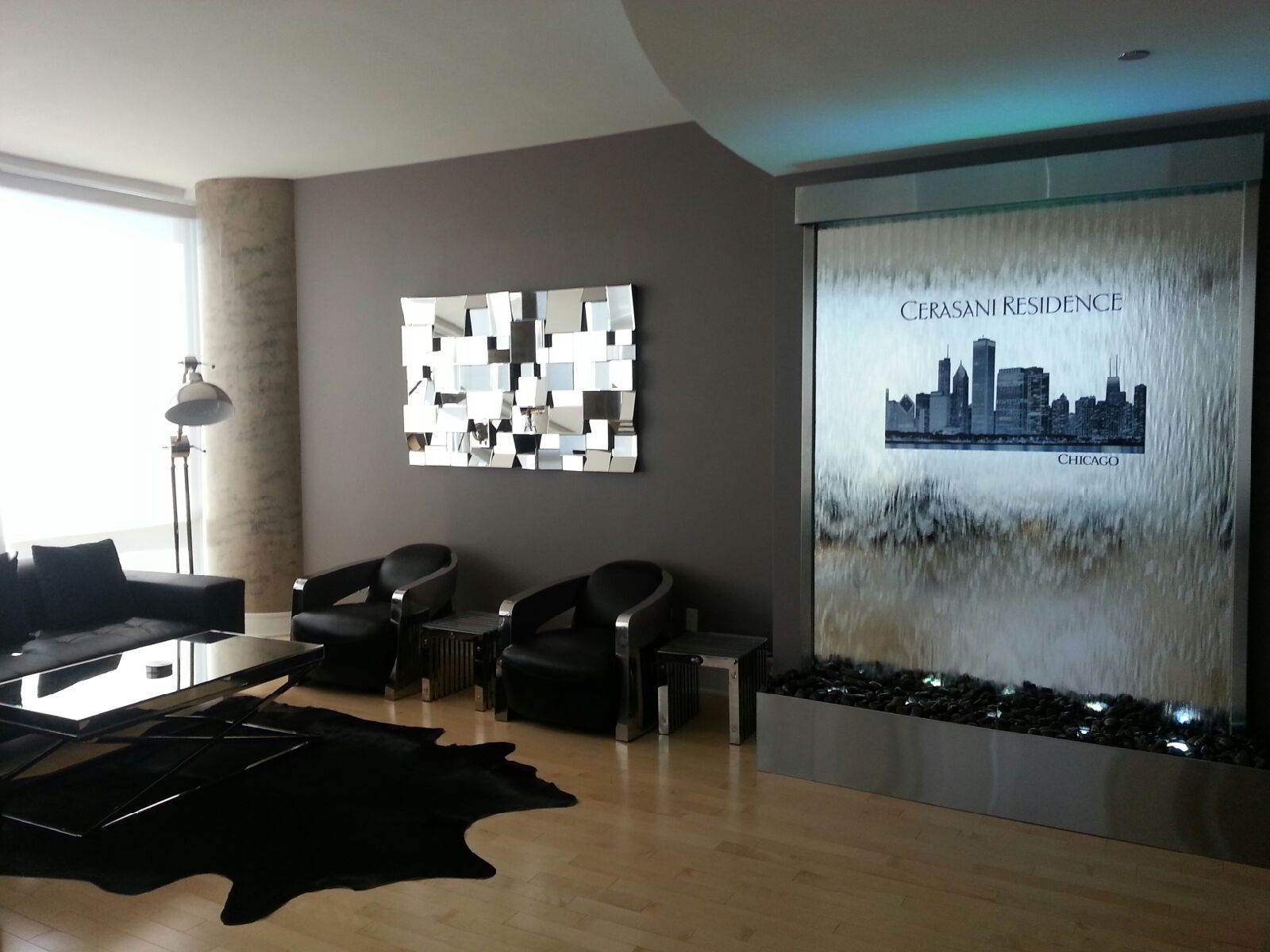 Logo Fountains 79 Mirror water wall waterfall featuring skyline design at Cerasani Residence in Chicago, enhancing modern interior aesthetics with a sleek black and silver decor.