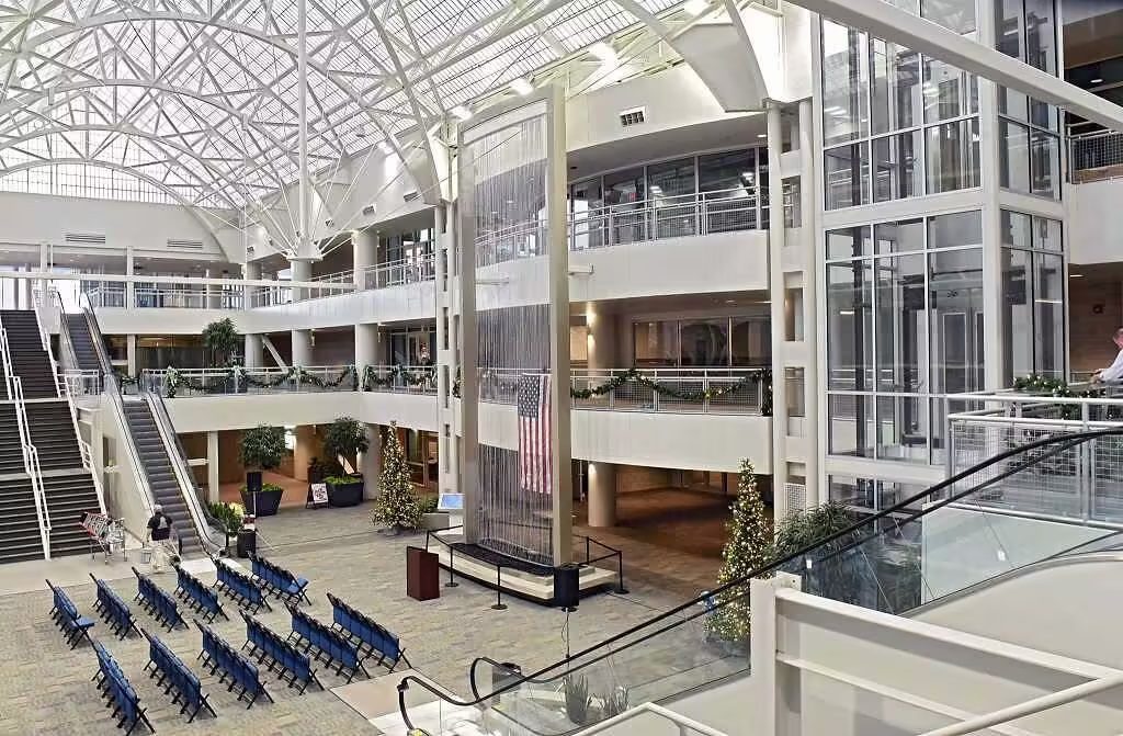 Indoor atrium featuring a modern water wall, seating arrangement, and decorative plants, enhancing the welcoming atmosphere in a commercial building.