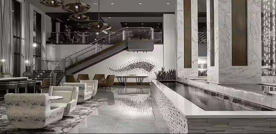 Modern lobby interior featuring a sleek water feature, elegant seating, and decorative elements, highlighting custom water features for commercial spaces.
