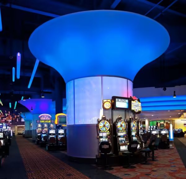 Vibrant blue-lit ceiling feature in a casino, showcasing modern slot machines and a lively gaming atmosphere.