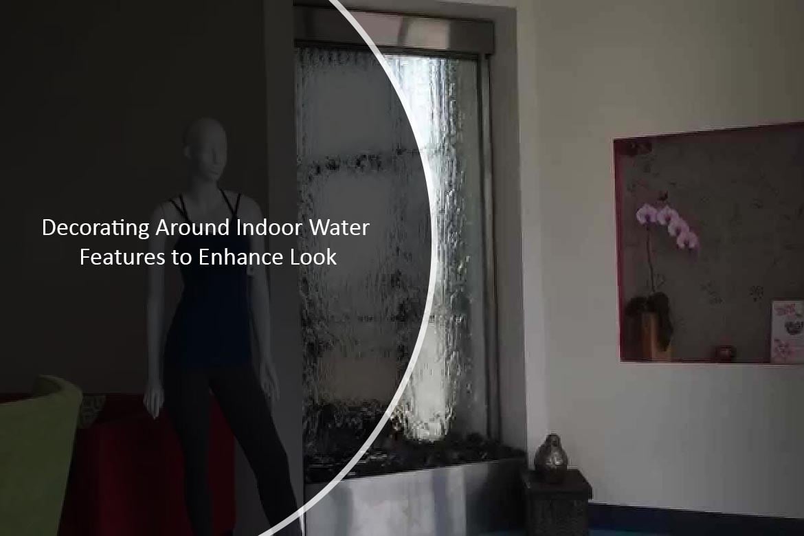 Indoor water feature with glass fountain wall, decorative elements including a mannequin and potted orchid, enhancing tranquil atmosphere.