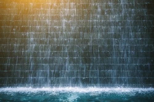 Indoor water wall feature with cascading water, enhancing ambiance and tranquility in commercial spaces.