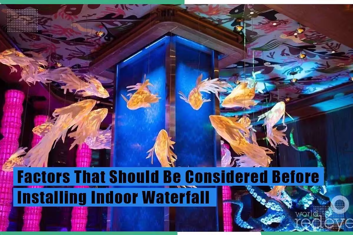 Indoor glass waterfall installation with illuminated fish and vibrant lighting, enhancing aesthetic appeal for commercial spaces, as discussed in context of factors to consider before installation.