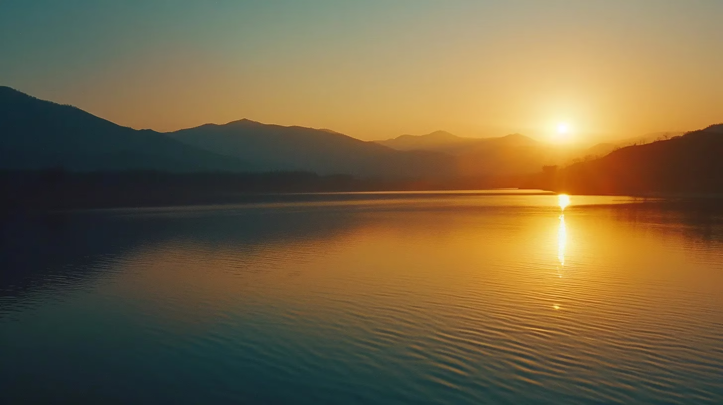 Create an Eye-Catching Water Display at Home 3 a vibrant sunrise casts golden rays over a tranquil lake, reflecting mountains in the distance and creating a serene atmosphere filled with soft hues of orange and blue.