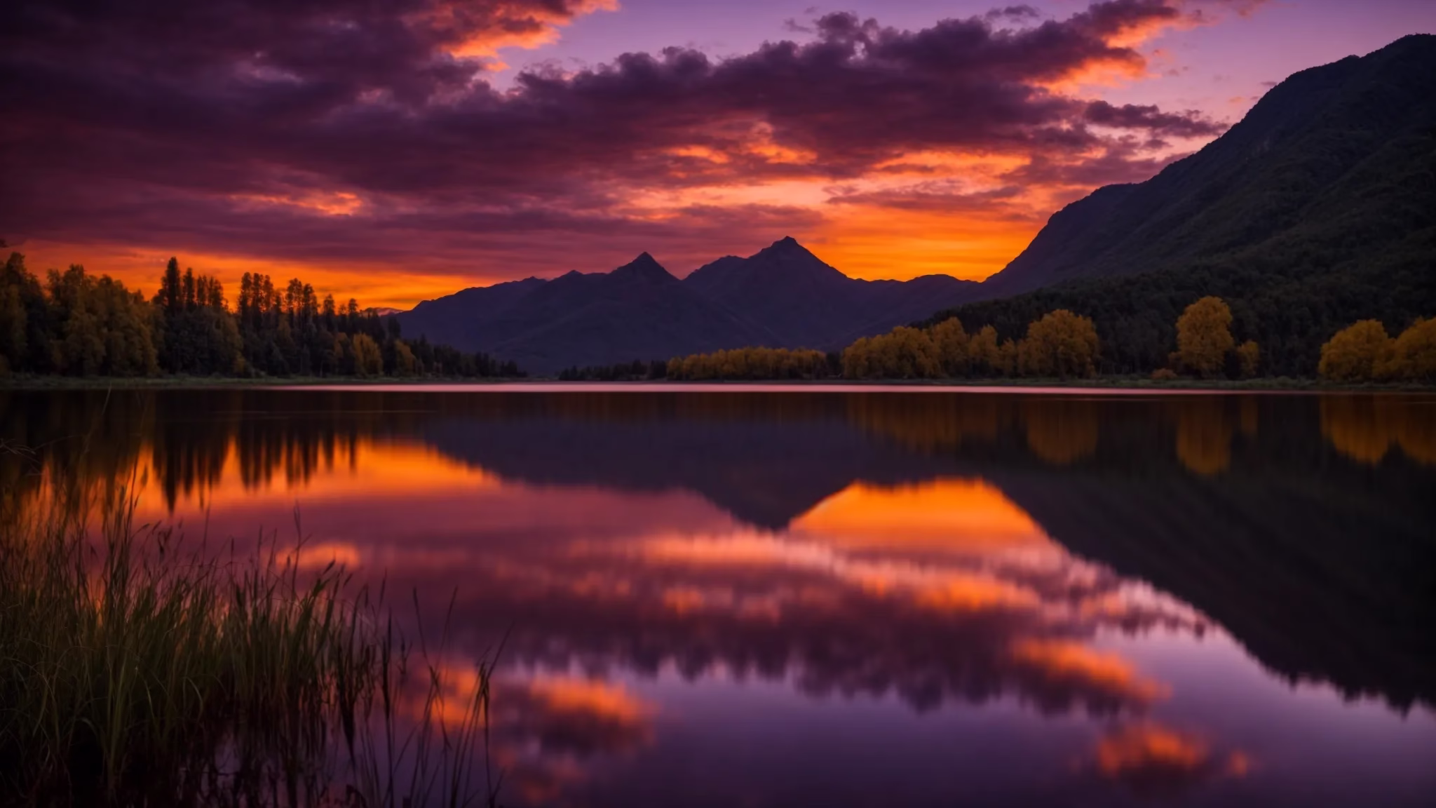 Water Feature Designers Bringing Serenity to Your Outdoors 2 a vibrant sunset casts a warm golden glow over a tranquil lake, reflecting the majestic silhouette of distant mountains under a sky painted with rich hues of orange and purple.