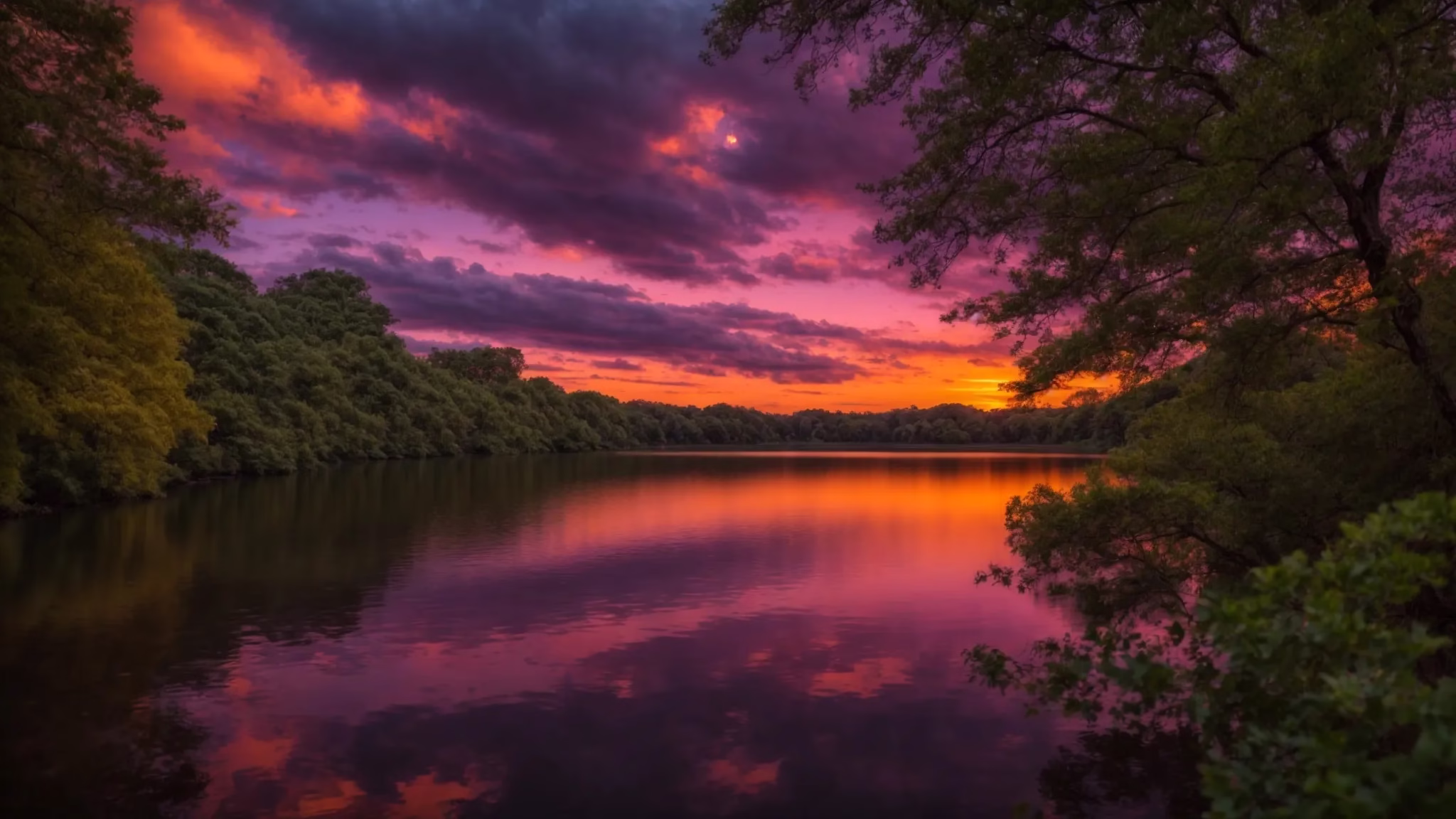 Elevate Your Outdoor Space With Stone Garden Fountains 1 a vibrant sunset paints the sky with brilliant hues of orange and purple, reflecting off a tranquil lake surrounded by lush green trees.