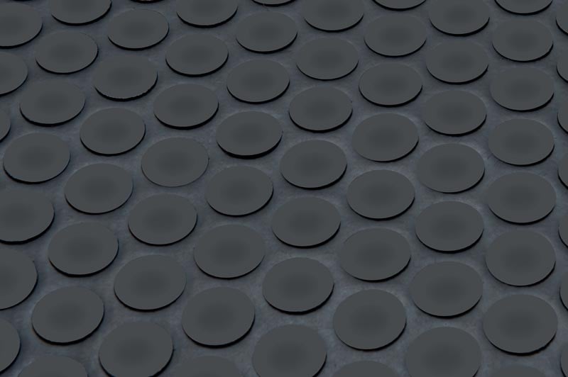 תקריב של מחצלת גומי מרקמת עם דפוס חוזר של בליטות עגולות בולטות, אידיאלי כמחצלת נגד החלקה או כמחצלת כניסה לעסק.