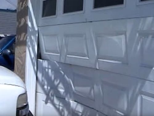 garage door that has been hit by a car