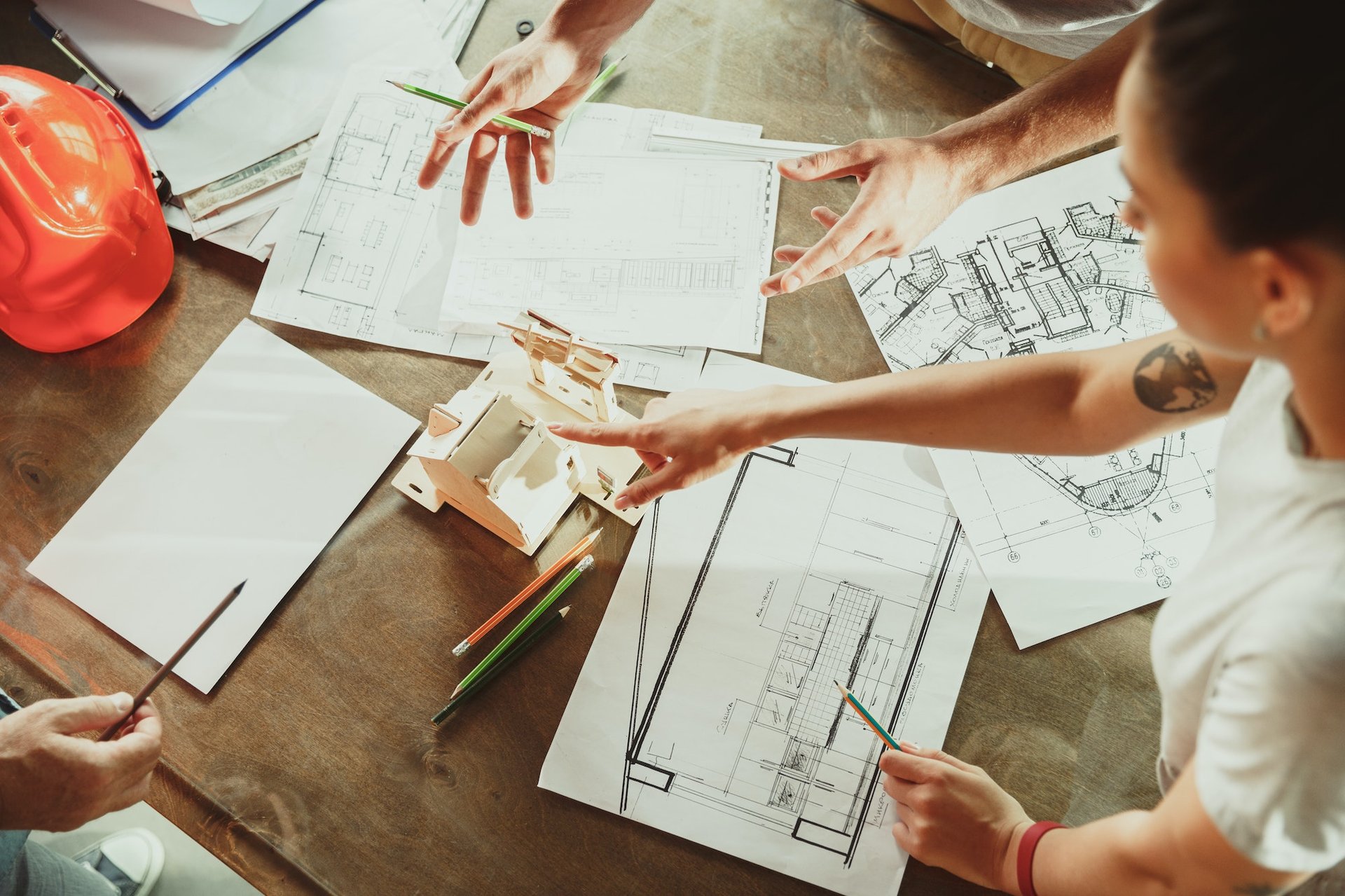 Foreman or achitect shows house, office or store design plans to a young couple