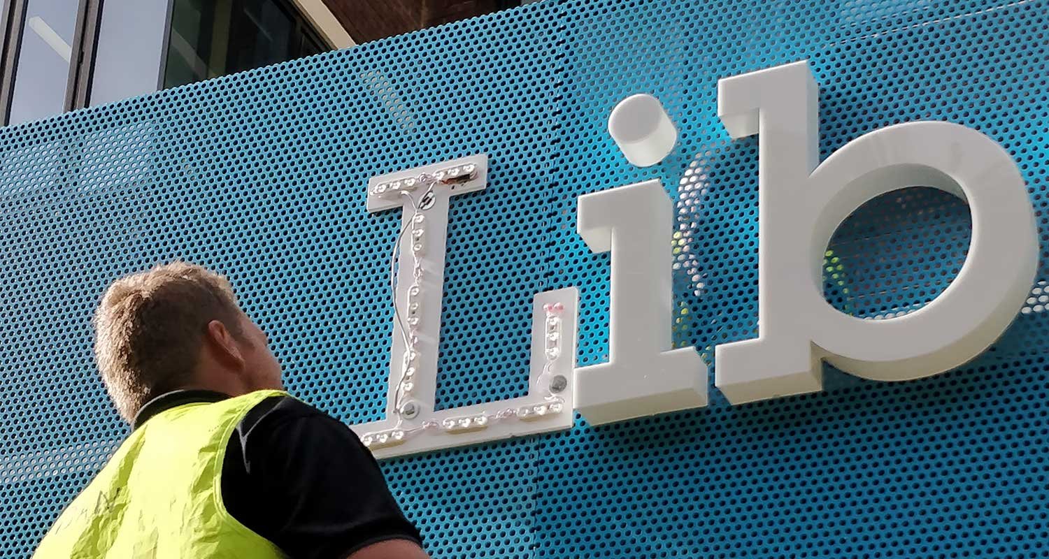 storefront-sign-ideas - City Signs of Texas storefront sign ideas. man installing channel letter signs