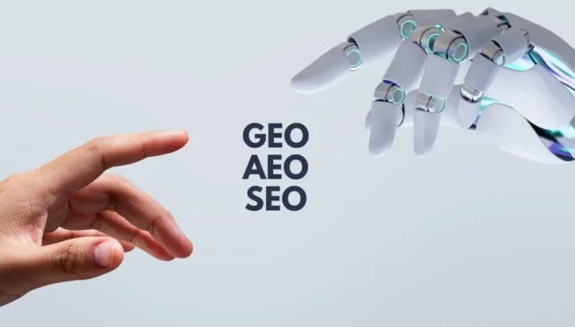 Eine menschliche Hand und eine Roboterhand strecken sich einander entgegen, dazwischen stehen die Worte "GEO Optimierung", "AEO Optimierung" und "SEO" auf einem hellen Hintergrund.