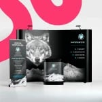 Modernes Messestand-Setup mit einem auffälligen Wolfsbild, Firmenlogo und Text in deutscher Sprache zur Werbung für IT-Dienste wie IT-Sicherheit, Infrastruktur und Cloud-Hosting.