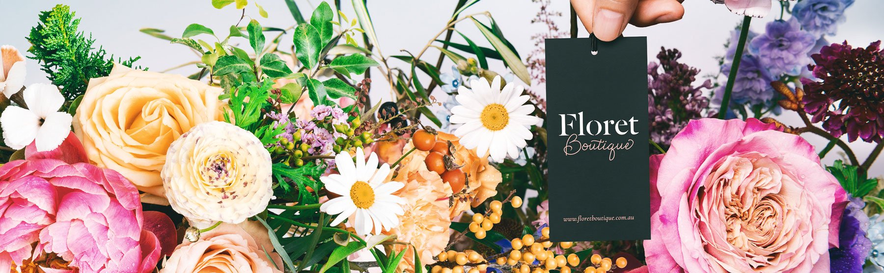 Banner featuring an array of vibrant flowers with a central black tag displaying "floret boutique" in white text, alongside a floral-themed website url.
