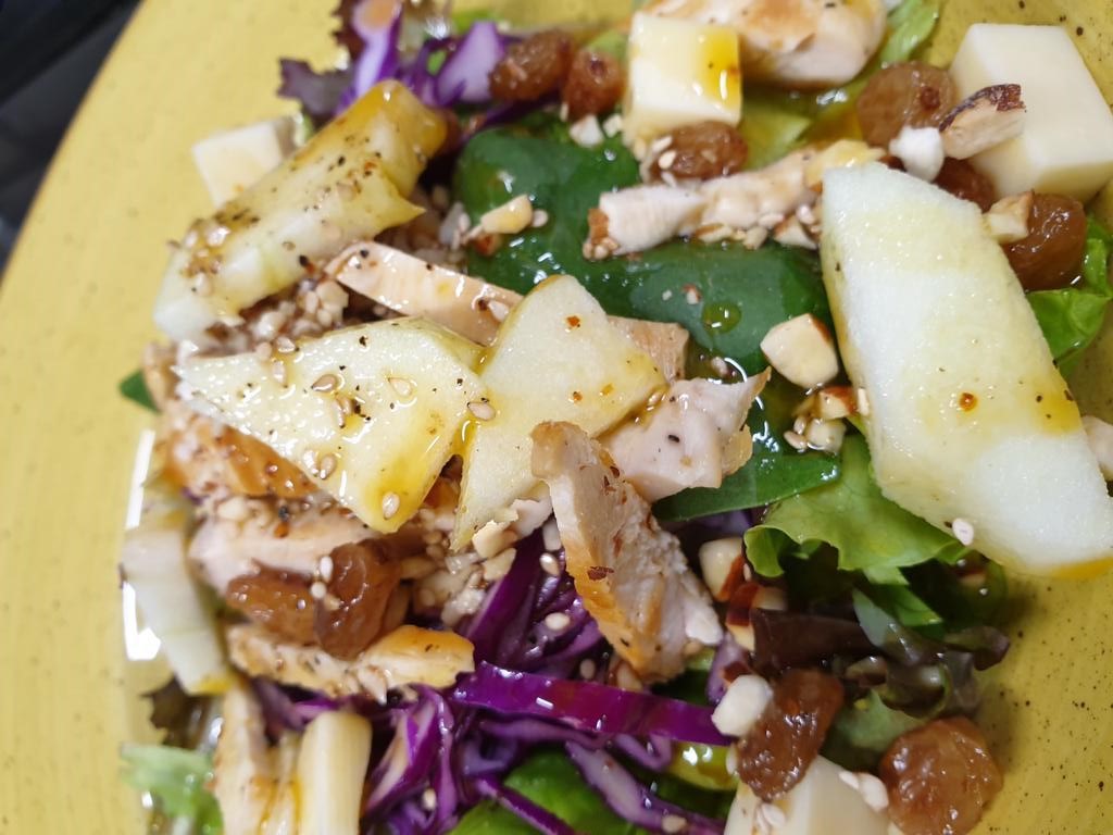 Ensalada de pollo con manzana, pasas, frutos secos y aderezo en restaurante de Santiago de Compostela – Una opción saludable y sabrosa para disfrutar en el menú del día de cafeterías locales.