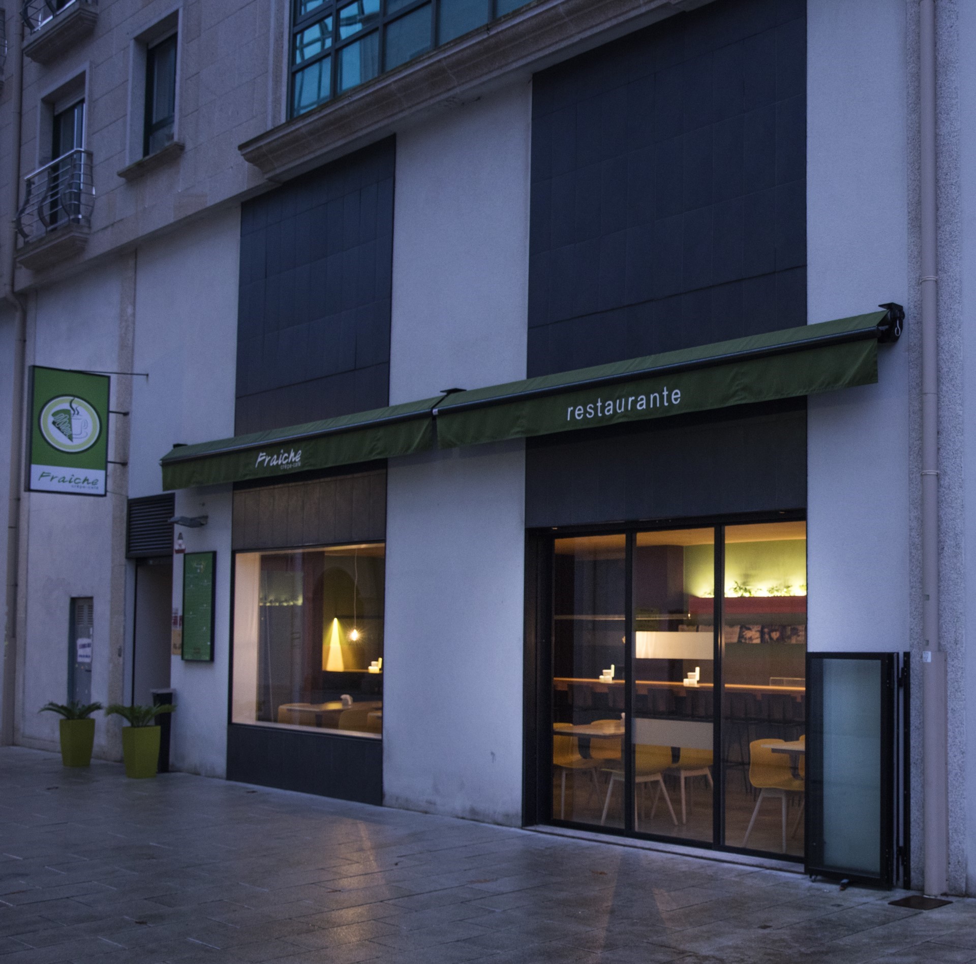 Fachada exterior del restaurante Praiché con toldo verde y cartel visible con nombre del local, en la ciudad de Santiago de Compostela