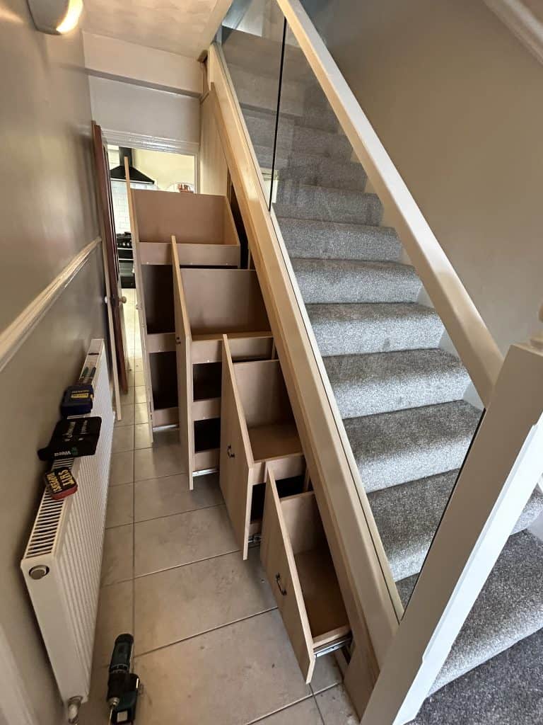 bottom view of staircase with pullout understairs storage