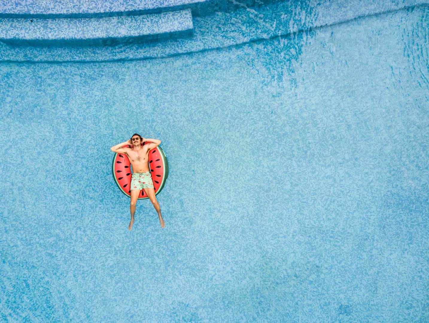 Man relaxing at swimming pool Relaxing in the middle of a swimming pool on a dinghy