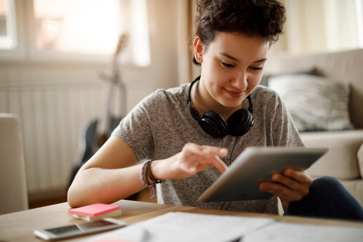 Smiling young woman using digital tablet at home Smiling young woman using digital tablet at home