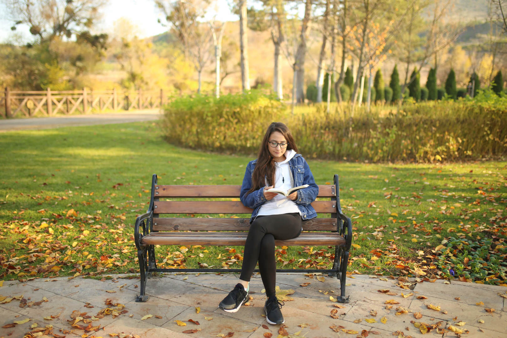 Woman sitting on the bench at the park and reading a book. Woman sitting on the bench at the park and reading a book.