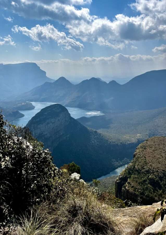 A view from above of the Blyde River Canyon with clouds and hazy skies
