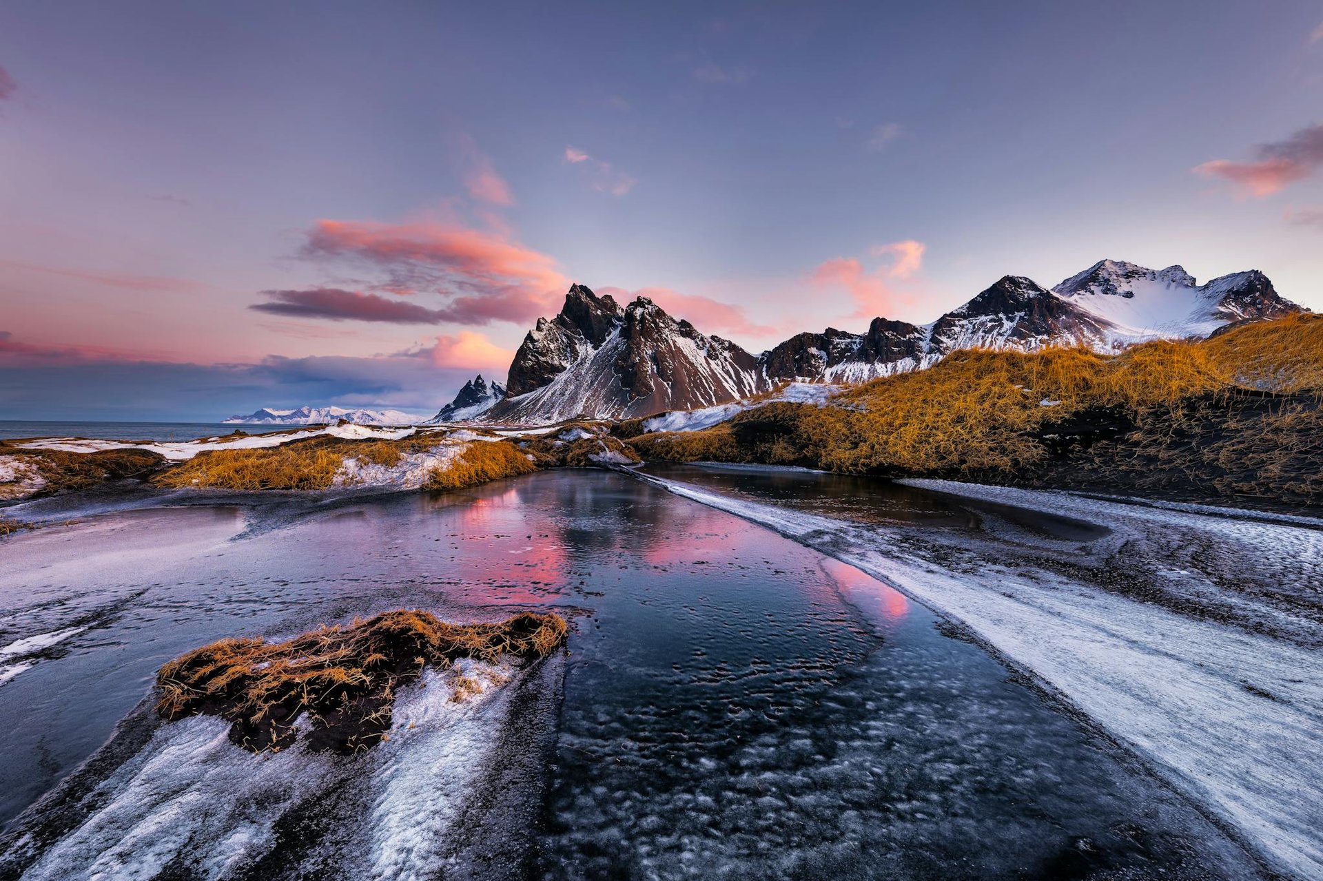 Vestrahorn mountains with frozen lake at sunset, stunning natural landscape.