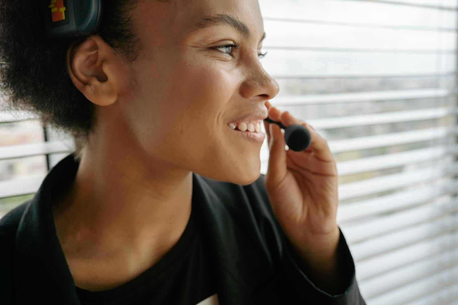 Sentiment analysis, Close-up of a smiling woman using a headset, ideal for customer service themes.