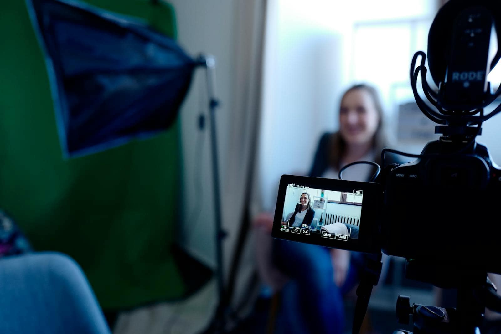 SEO, Google Keyword Planner, Woman being recorded in a professional studio setup, using video camera and lighting equipment.