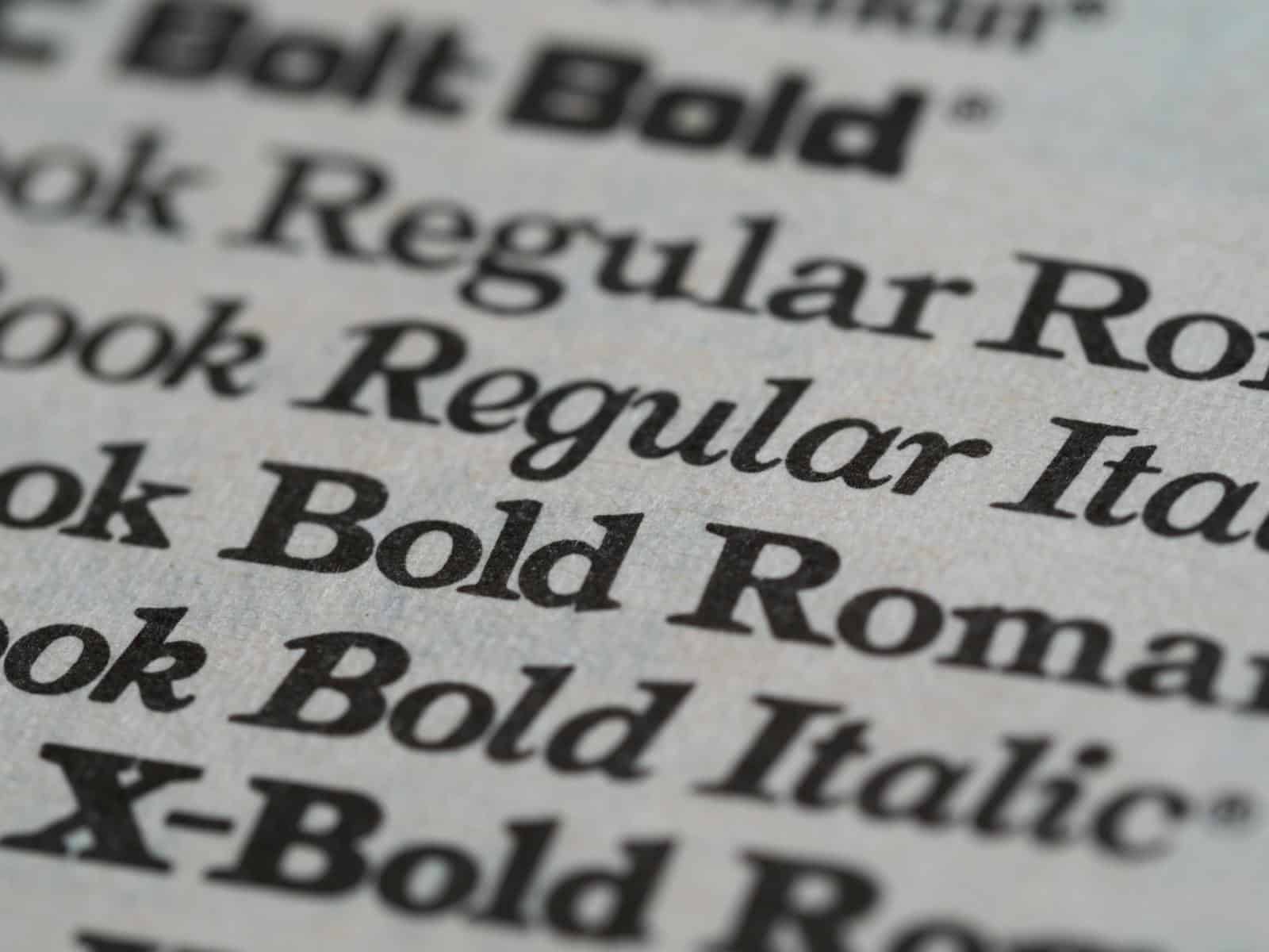 Logo Design, Detailed view of different font styles printed on paper, showcasing typography.