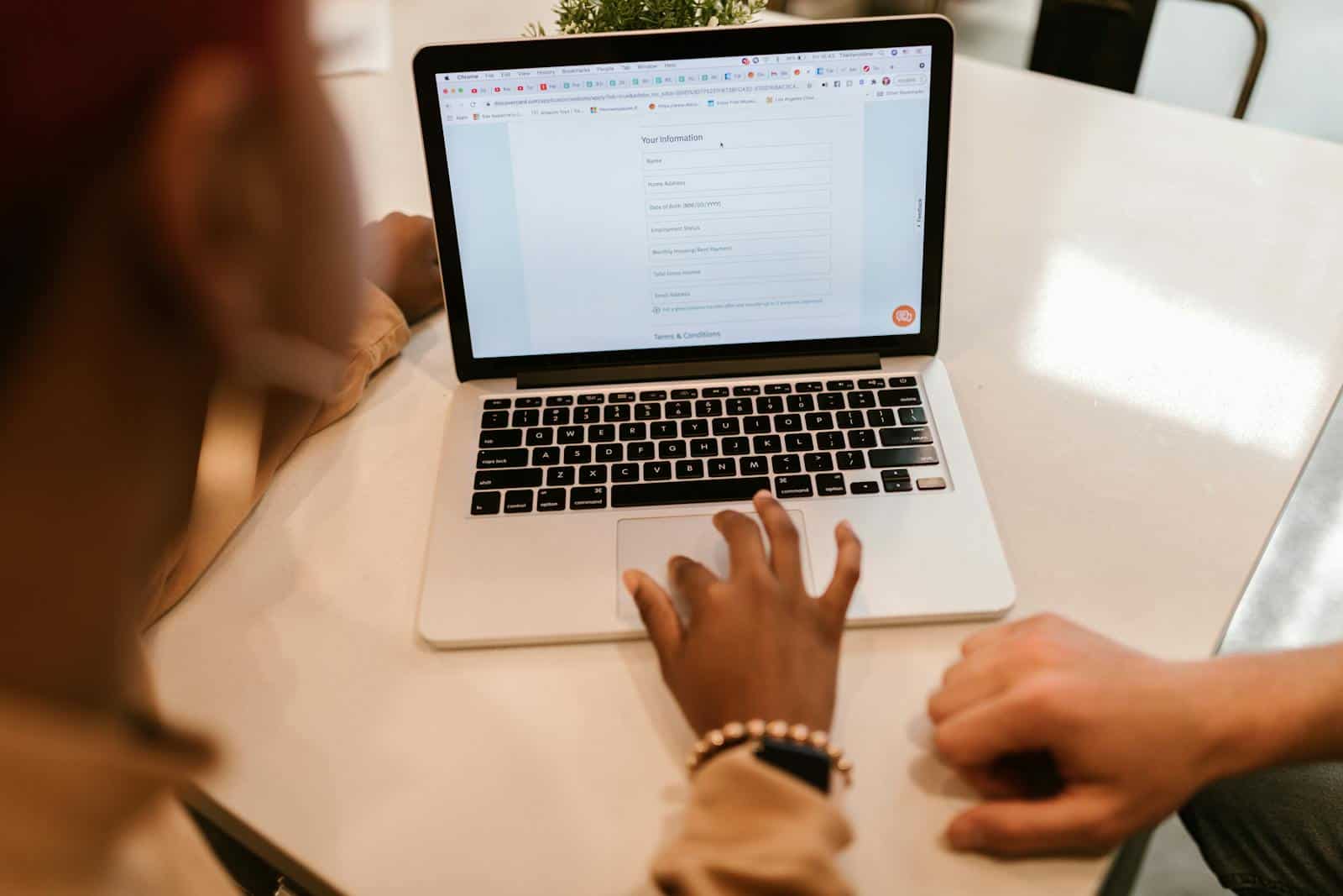 Data Quality, Survey Design, Two adults working together on a laptop displaying an online form, indoors.