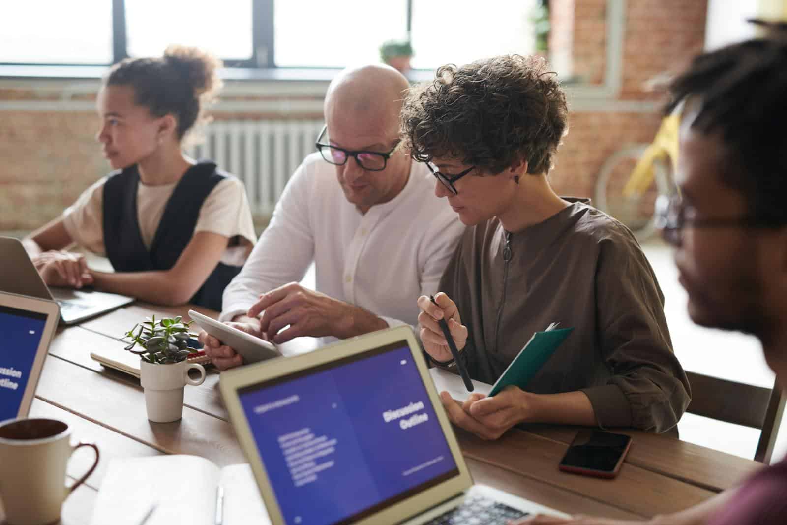Data Quality: Survey Design, A group of adults working together on laptops and tablets in a modern office setting.